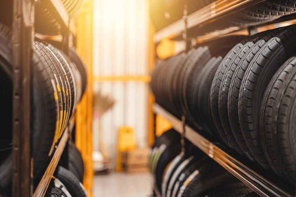 tire size, auto repair in Marion, IL at Hale's Automotive. Rows of new tires stacked on shelves in an auto shop.