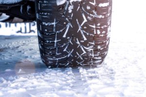 snow tire services in Marion, IL, auto repair in Marion IL at Hale's Automotive. Close-up view of a winter tire on a snow-covered road.